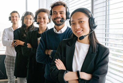 Équipe de service à la clientèle souriante portant des casques-microphones dans un bureau