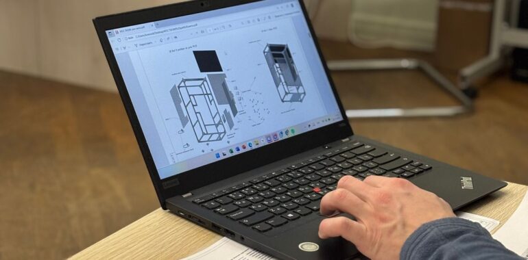 Entrepreneur consultant des plans et un devis sur un ordinateur portable, illustrant un agent IA pour les appels d'offres