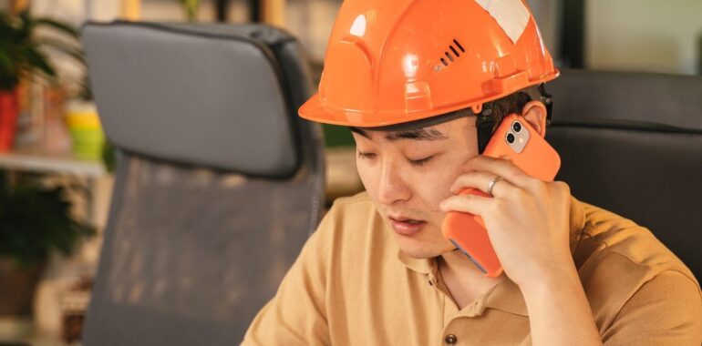 Travailleur de la construction au téléphone devant des plans, illustrant la cyberattaque CCQ et la protection Equifax des employés