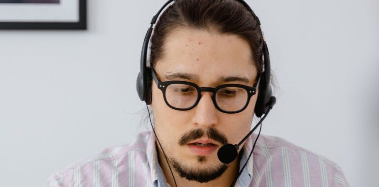 Technicien de soutien à distance avec casque d'écoute devant un ordinateur portable, illustrant la faille BeyondTrust Remote Support