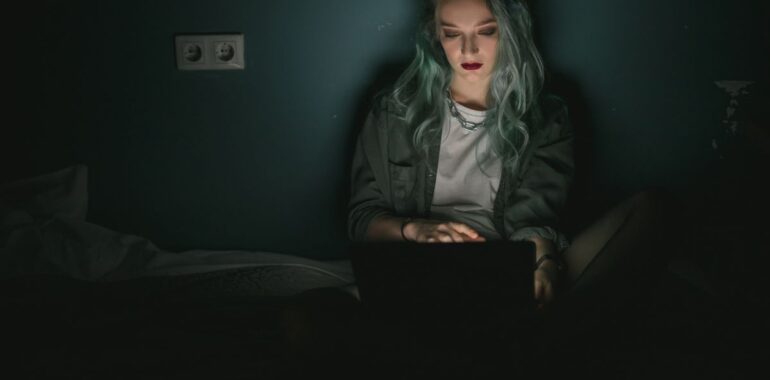 Personne seule devant un portable dans une pièce sombre, illustrant une connexion VPN pirate via la faille GlobalProtect