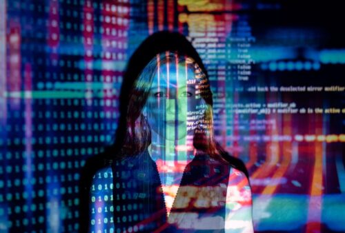 Code informatique projeté sur le visage d'une femme, illustrant la faille Ivanti Connect Secure exploitée en zero-day