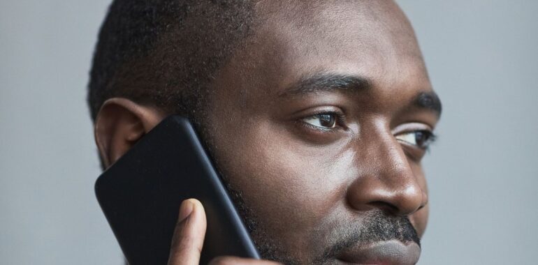 Homme au téléphone, illustrant la faille Signal qui garde un appel ouvert après avoir raccroché