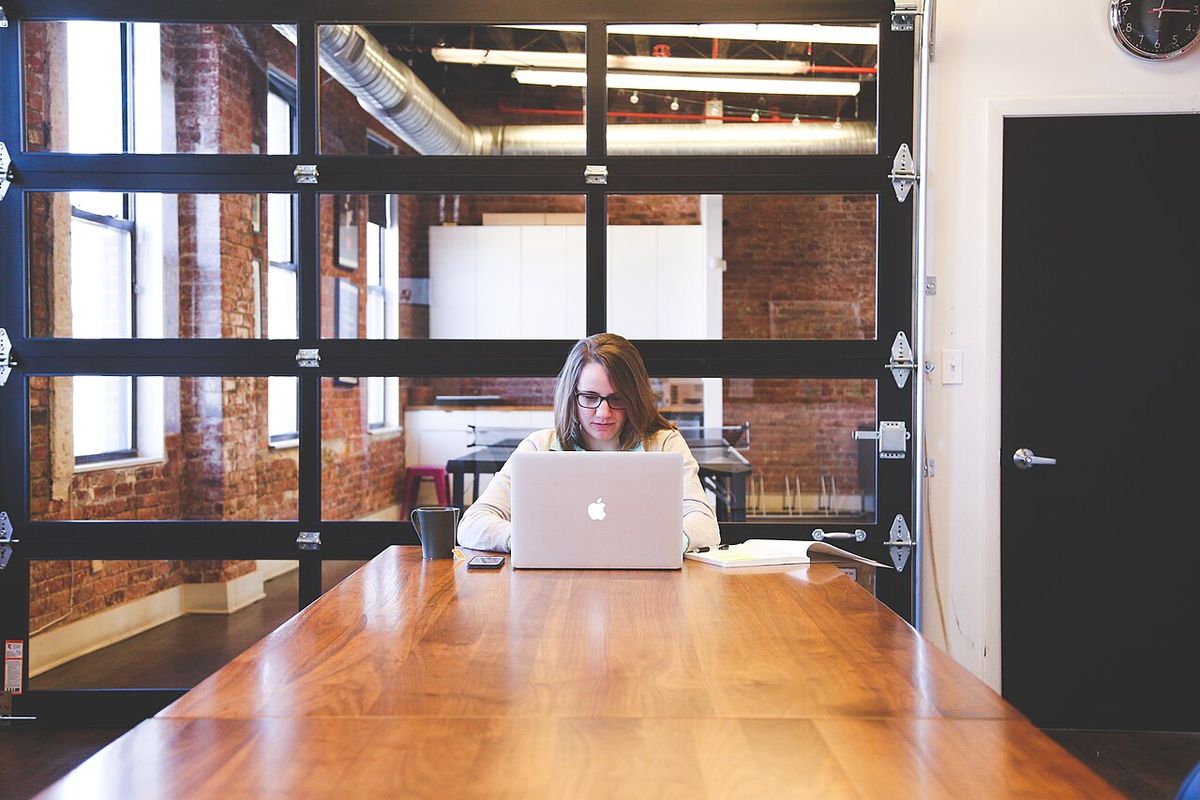 Employée qui travaille sur un ordinateur portable dans un bureau à aire ouverte