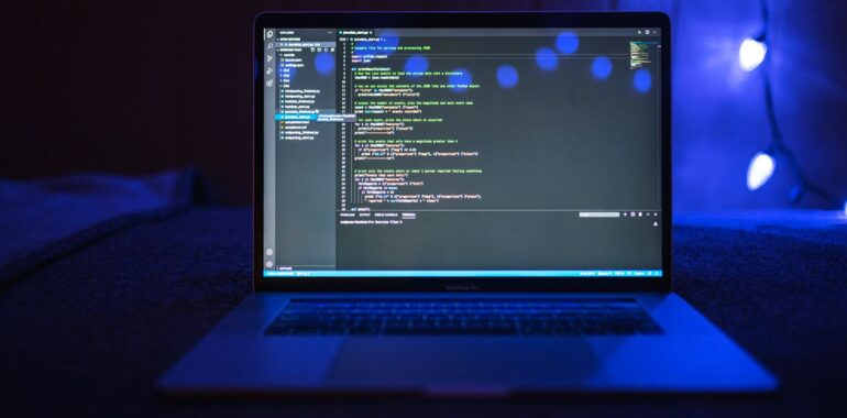 Portable ouvert affichant du code dans une pièce sombre, illustrant le piratage de l'outil OVHcloud CLI