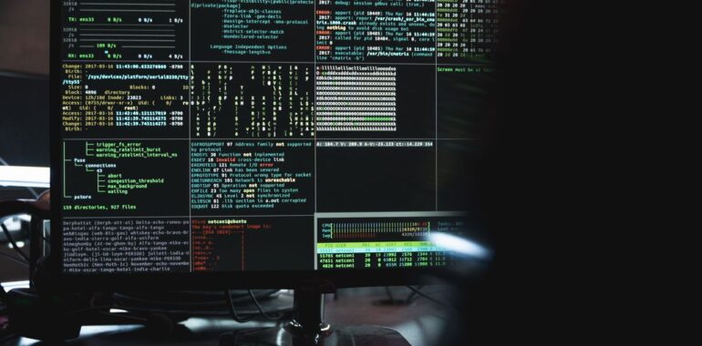 Écran affichant du code et des lignes de commande dans une pièce sombre, illustrant de vieilles failles encore exploitées