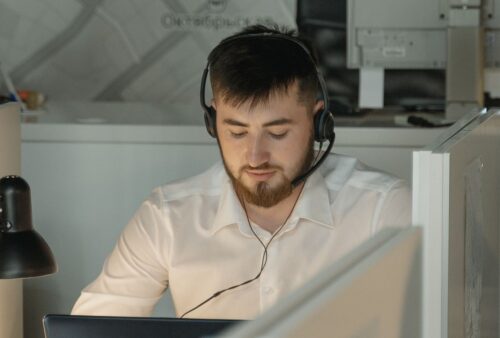 Agent de soutien technique portant un casque-micro devant son ordinateur
